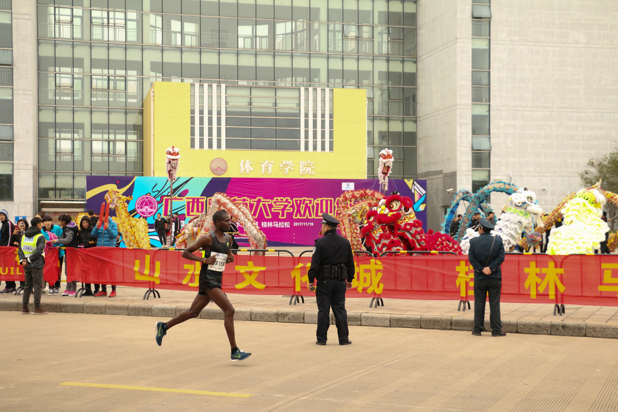 运动员路过舞狮现场2（大学生通讯社罗丽婷摄）9.jpg