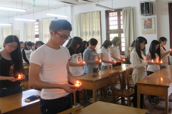 同学们手捧蜡烛默哀