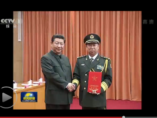 视频截图：习近平总书记为校友李作成颁发上将命令状