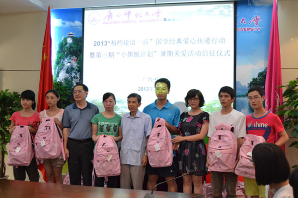 与会领导为“爱心大使”发放爱心包，由其带回家乡转赠给孤儿