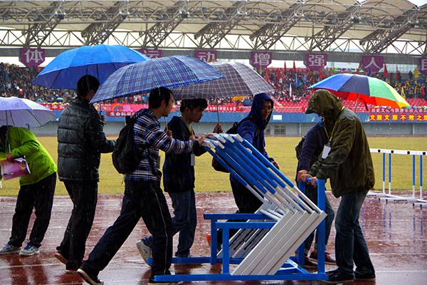 雨中搬运器材的志愿者们 （大学生通讯社 陈海波 摄 ）