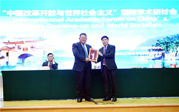 广西师范大学党委书记邓军教授与老挝代表团宋森·赛雅翁所长互赠礼物.jpg
